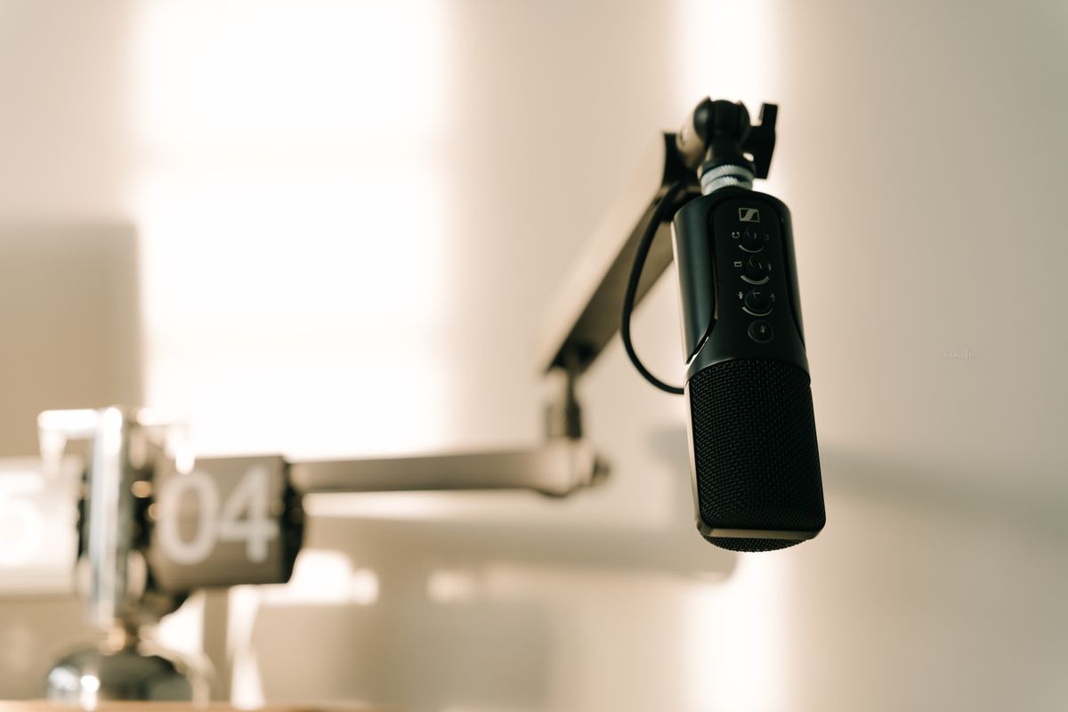 Studio microphone on a boom arm in a minimalist recording booth