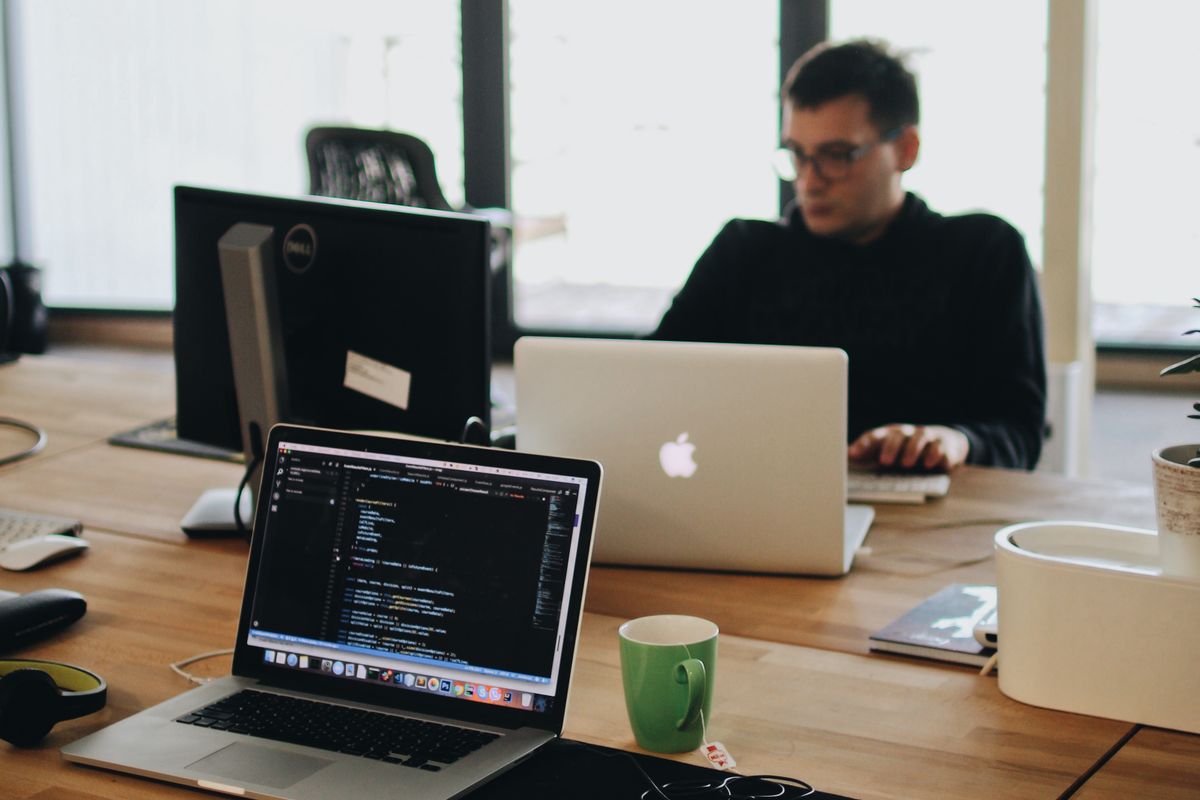 Developer at work across a laptop and a second display