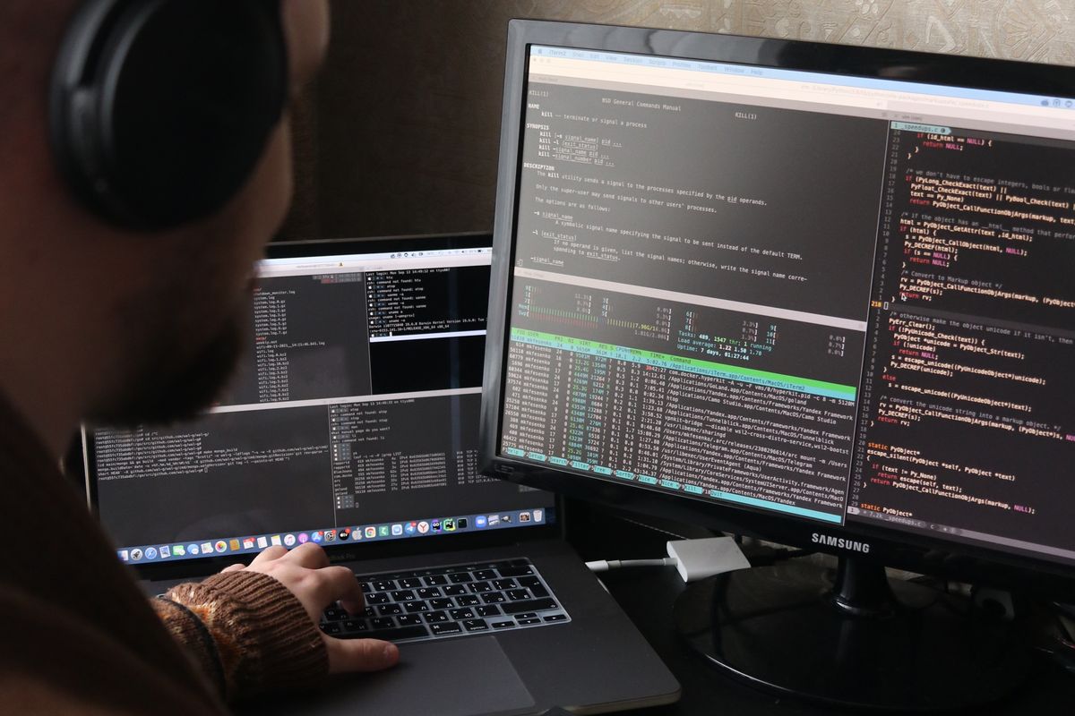 Developer writing software across dual monitors