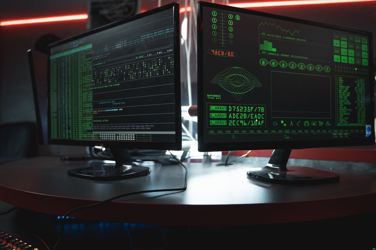 Dual monitors showing terminal output in a darkened room