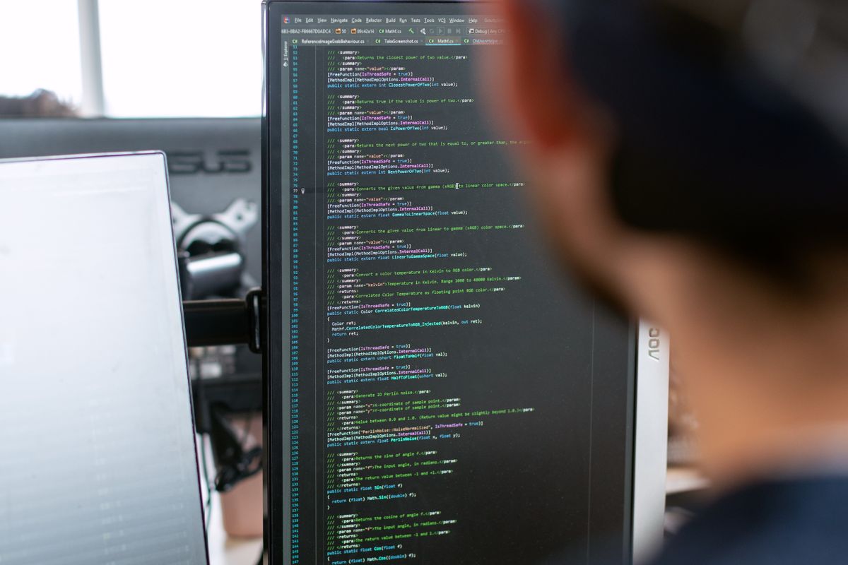 Software engineer writing code in an open-plan office