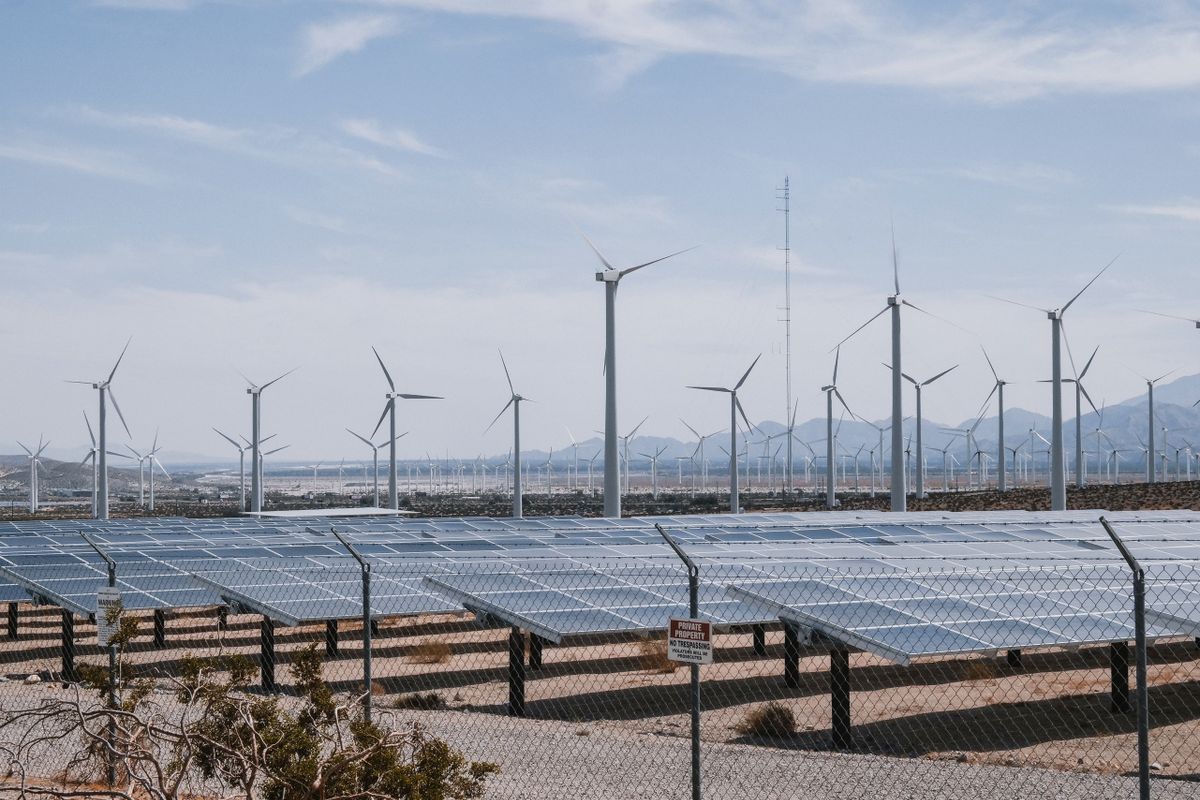 Wind turbines and solar arrays across an energy farm